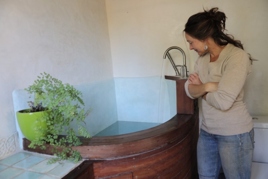 Massey Burke looking down into a tiny bathtub in her home